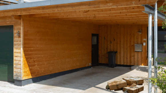A photo showing wet cardboard boxes underneath the carport of a house with the words "general pest tips" on the photo